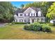 Charming two-story home with a well-manicured lawn, mature trees, and a welcoming front porch at 5735 Lake Windsor Pkwy, Buford, GA 30518