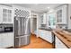 Bright kitchen with white cabinets, stainless steel refrigerator, and hardwood floors at 5735 Lake Windsor Pkwy, Buford, GA 30518