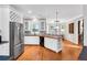 Well-lit kitchen featuring white cabinets, stainless steel appliances, and hardwood floors at 5735 Lake Windsor Pkwy, Buford, GA 30518