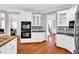 Bright kitchen features white cabinetry, tile backsplash, stainless steel appliances, and wood floors at 5735 Lake Windsor Pkwy, Buford, GA 30518