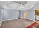 Spacious primary bedroom with tray ceilings, fan and ensuite bathroom at 5735 Lake Windsor Pkwy, Buford, GA 30518