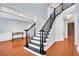 Elegant staircase with black railings and white trim in a home with hardwood floors at 5735 Lake Windsor Pkwy, Buford, GA 30518