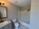 Bathroom featuring tile floors, gray vanity, shower and bathtub combo, and modern lighting at 6798 Blackstone Pl # 12, Mableton, GA 30126