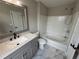 Bathroom showcasing marble floors, white tiled shower and bathtub combo, and gray vanity at 6798 Blackstone Pl # 12, Mableton, GA 30126