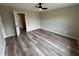 Bedroom with wood-look flooring, ceiling fan, neutral walls, and a connecting doorway at 6798 Blackstone Pl # 12, Mableton, GA 30126