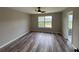 A bedroom with hardwood floors, a ceiling fan, a window, and an adjacent bathroom at 6798 Blackstone Pl # 12, Mableton, GA 30126