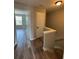 Hallway featuring wood-look flooring, staircase, and doorway to the adjacent room at 6798 Blackstone Pl # 12, Mableton, GA 30126