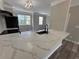 A well-lit kitchen with a quartz countertop, black sink, and view of living room windows at 6798 Blackstone Pl # 12, Mableton, GA 30126