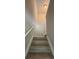 Carpeted staircase leading to the upper level, featuring neutral walls and a white handrail at 6798 Blackstone Pl # 12, Mableton, GA 30126