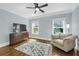 A blue bedroom with wood floors featuring a television, dresser, chair and natural light at 328 Brownstones Cir, Atlanta, GA 30312