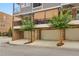 Townhome garages with brick base, neutral paint, lovely trees, and concrete parking at 328 Brownstones Cir, Atlanta, GA 30312