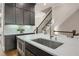 Kitchen island with stainless sink, marble countertop, microwave, and adjacent staircase at 328 Brownstones Cir, Atlanta, GA 30312