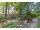 Backyard featuring a stone pathway, lush greenery, and a cozy seating area under the shade of mature trees at 4105 Vicksburg Dr, Lawrenceville, GA 30044