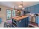 Bright kitchen featuring a center island, blue cabinets, stainless appliances and access to back patio at 4105 Vicksburg Dr, Lawrenceville, GA 30044