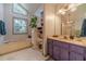 Bright bathroom features a soaking tub, double window, and purple vanity at 4105 Vicksburg Dr, Lawrenceville, GA 30044