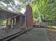 Exterior view showcasing brick siding, deck, carport, and lush backyard at 510 Se Boyds Se Dr, Marietta, GA 30067