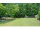 The property boasts a large, well-maintained backyard, partially fenced, with storage shed, and surrounded by mature trees at 5340 Harris Creek Dr, Cumming, GA 30040