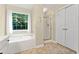 Bright bathroom featuring a garden tub under a large window and a separate glass-enclosed shower at 5340 Harris Creek Dr, Cumming, GA 30040