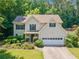 Two-story home with lush landscaping, a two car garage and an inviting front entrance at 5340 Harris Creek Dr, Cumming, GA 30040