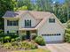 Charming two-story home featuring a manicured front yard with flowering shrubs and an attached two-car garage at 5340 Harris Creek Dr, Cumming, GA 30040
