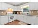 The kitchen is equipped with modern appliances, granite countertops and ample cabinet space, under a bright window at 5340 Harris Creek Dr, Cumming, GA 30040