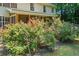 A beautifully landscaped backyard with colorful roses surrounds a screened porch with view of a lush wooded property at 5340 Harris Creek Dr, Cumming, GA 30040