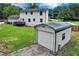 Backyard featuring a large metal storage shed, green grass, and a partial view of the house at 175 Hunters Gln, Fayetteville, GA 30215