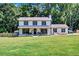 Beautiful two-story home boasts a welcoming front porch and colorful landscaping, enhancing its curb appeal at 175 Hunters Gln, Fayetteville, GA 30215