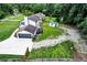 Aerial view of home's rear exterior with garage, long driveway, shed, and lush landscaping at 175 Hunters Gln, Fayetteville, GA 30215