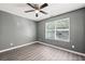 Bright bedroom featuring a ceiling fan, hardwood floors, and a sunlit window at 3303 Par Three Way, Lithonia, GA 30038