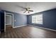 This bedroom includes hardwood floors, a ceiling fan, and natural light from the window at 3303 Par Three Way, Lithonia, GA 30038