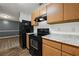 Open kitchen with black appliances, wood cabinets, and easy access to the dining area at 3303 Par Three Way, Lithonia, GA 30038