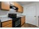 Kitchen features black oven, wood cabinets, laminate countertop and white door at 3303 Par Three Way, Lithonia, GA 30038