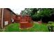 A backyard showcasing an elevated wood deck and a grass area with an outdoor fireplace at 3769 Amber Nw Rd, Atlanta, GA 30331