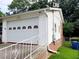 Close-up of a white garage with decorative windows and a brick foundation, showcasing side access at 3769 Amber Nw Rd, Atlanta, GA 30331