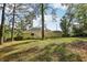 The backyard features a large grassy area and is surrounded by mature trees at 4954 Browns Mill Rd, Lithonia, GA 30038