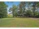 Lush backyard featuring mature trees creating privacy and serene setting at 600 Cowan Rd, Covington, GA 30016