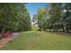Picturesque backyard featuring lush lawn with mature trees and a hen house at 600 Cowan Rd, Covington, GA 30016