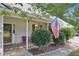 Welcoming front porch with an American flag, red bench, and neatly trimmed bushes creating charm at 600 Cowan Rd, Covington, GA 30016