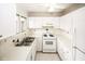 Cozy kitchen features white appliances, updated cabinets, and tiled countertops at 1200 Ashborough Se Ter # A, Marietta, GA 30067