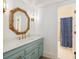 Charming bathroom with vanity, octagon mirror, and a shower/tub combo with a decorative blue curtain at 1565 Kings Xing, Smoke Rise, GA 30087