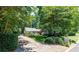 Long driveway leading to a charming home, surrounded by lush greenery, ensuring privacy and curb appeal at 1565 Kings Xing, Smoke Rise, GA 30087