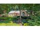 Charming one-story home with a well-manicured lawn, lush greenery, and mature trees at 1565 Kings Xing, Smoke Rise, GA 30087