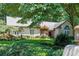 Beautiful one-story home featuring lush landscaping and a well-manicured lawn at 1565 Kings Xing, Smoke Rise, GA 30087