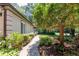 Manicured walkway with lush flowers and greenery leading to the side entrance of a charming home at 1565 Kings Xing, Smoke Rise, GA 30087