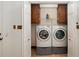 Laundry closet with tile floor, side-by-side washer and dryer, and upper cabinets at 1565 Kings Xing, Smoke Rise, GA 30087