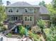 Back exterior view of a house with a deck, patio area, and lush landscaping at 505 Armor Knl, Powder Springs, GA 30127