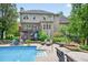 Expansive backyard featuring an inviting pool, patio area and lush landscaping at 505 Armor Knl, Powder Springs, GA 30127