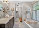 A bright bathroom featuring a double vanity, tub and views into the hallway at 505 Armor Knl, Powder Springs, GA 30127