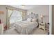 Comfortable bedroom with a large window, ornamental headboard and an all-white bedspread at 505 Armor Knl, Powder Springs, GA 30127